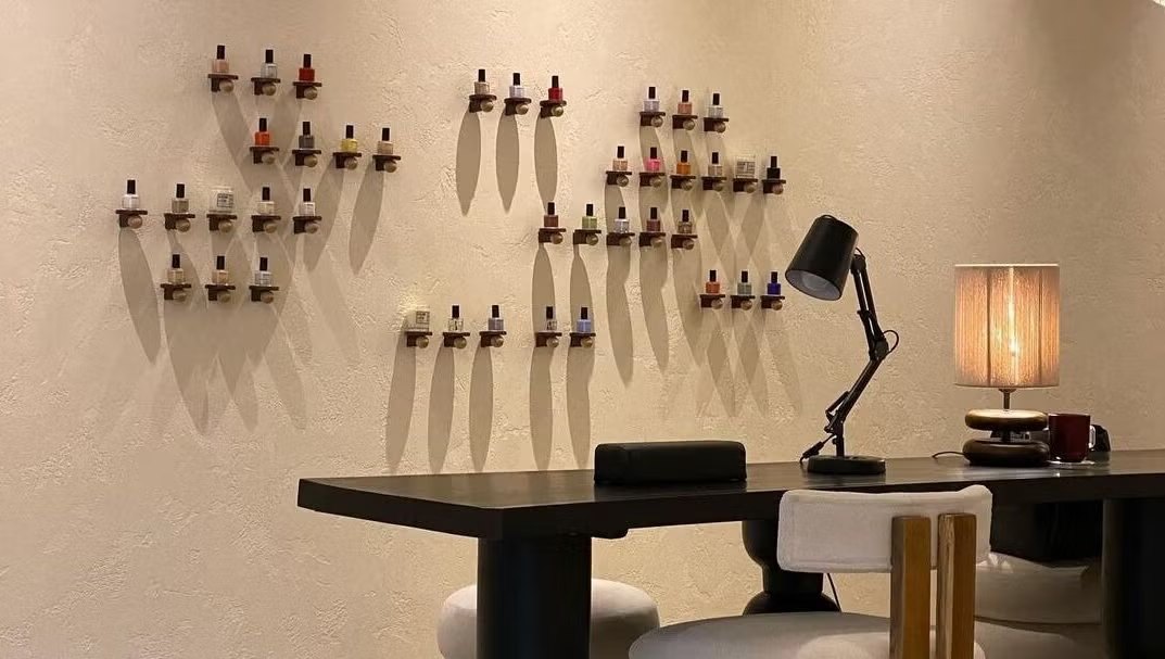 Wall of nail polish bottles above the manicure desk